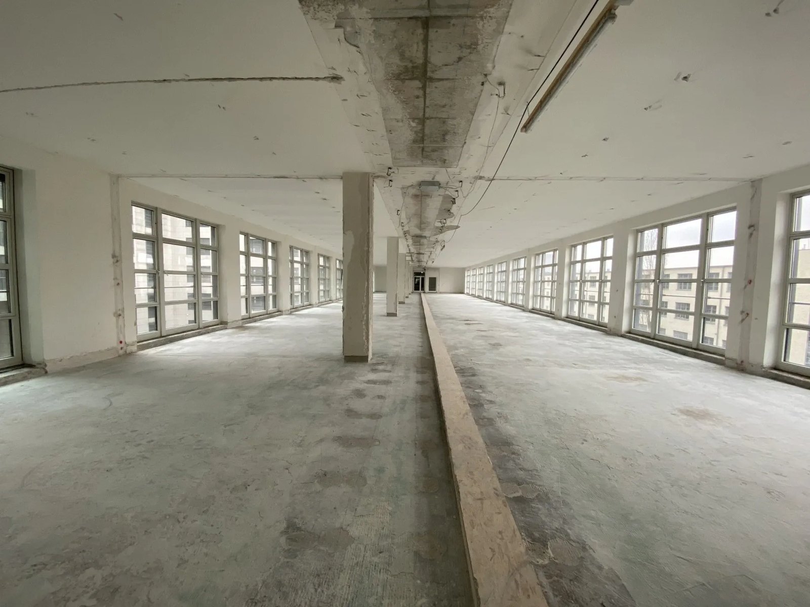 Vollständig entkerntes Bürogeschoss mit Panoramafenstern im Rohbauzustand nach der Entkernung durch HSM GmbH