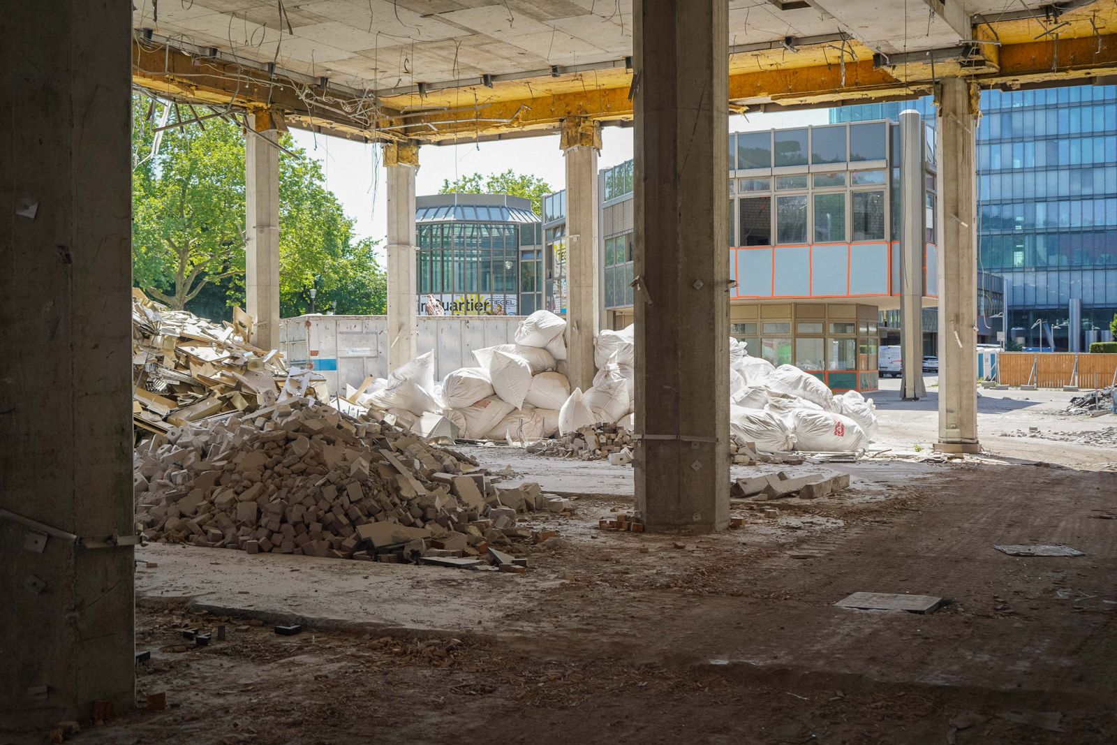 Bis auf den Rohbau entkernter Innenraum mit Betonstuetzen, Bauschutthaufen und Big Bags