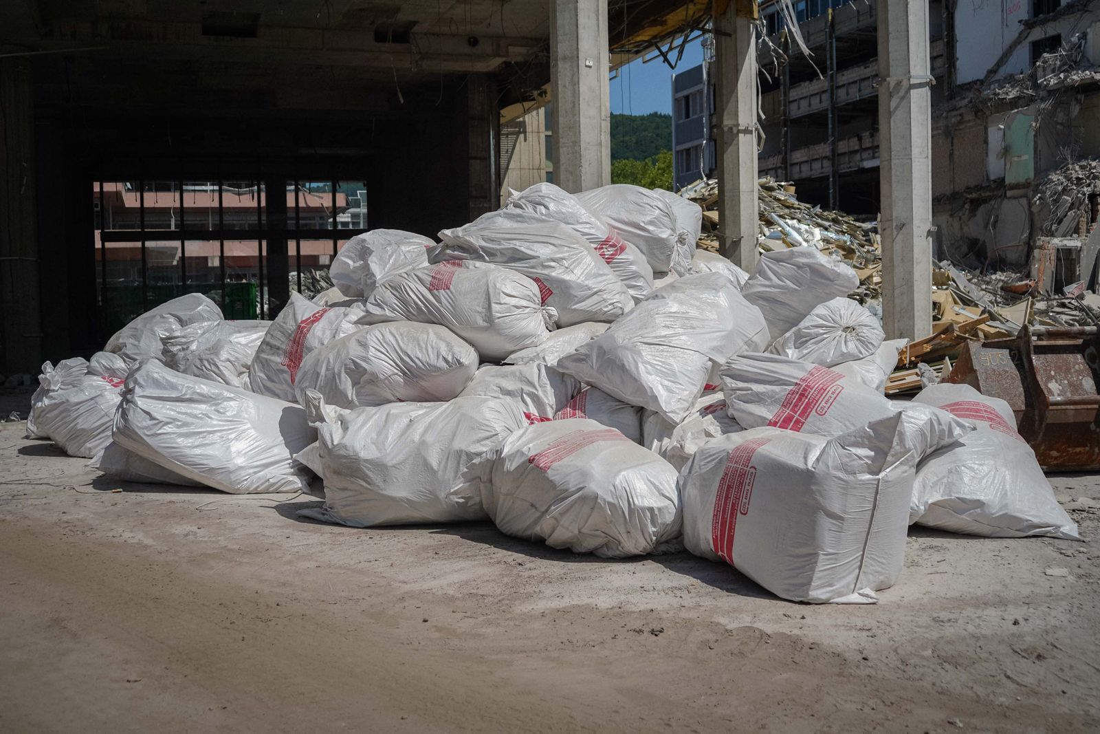 Gefuellte Schuttsaecke zur Entsorgung im Rohbau eines rueckgebauten Gebaeudes mit Betonstuetzen