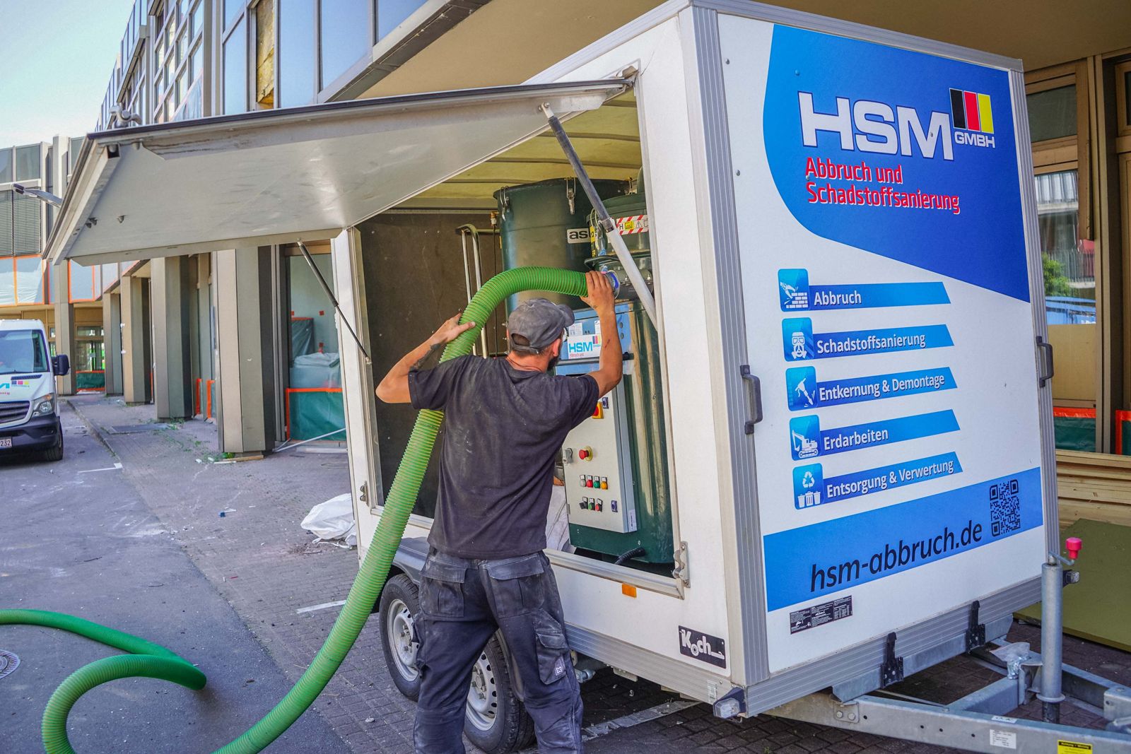 HSM-Mitarbeiter rüstet die Absaug- und Filtertechnik am HSM-Anhänger für die Schadstoffsanierung