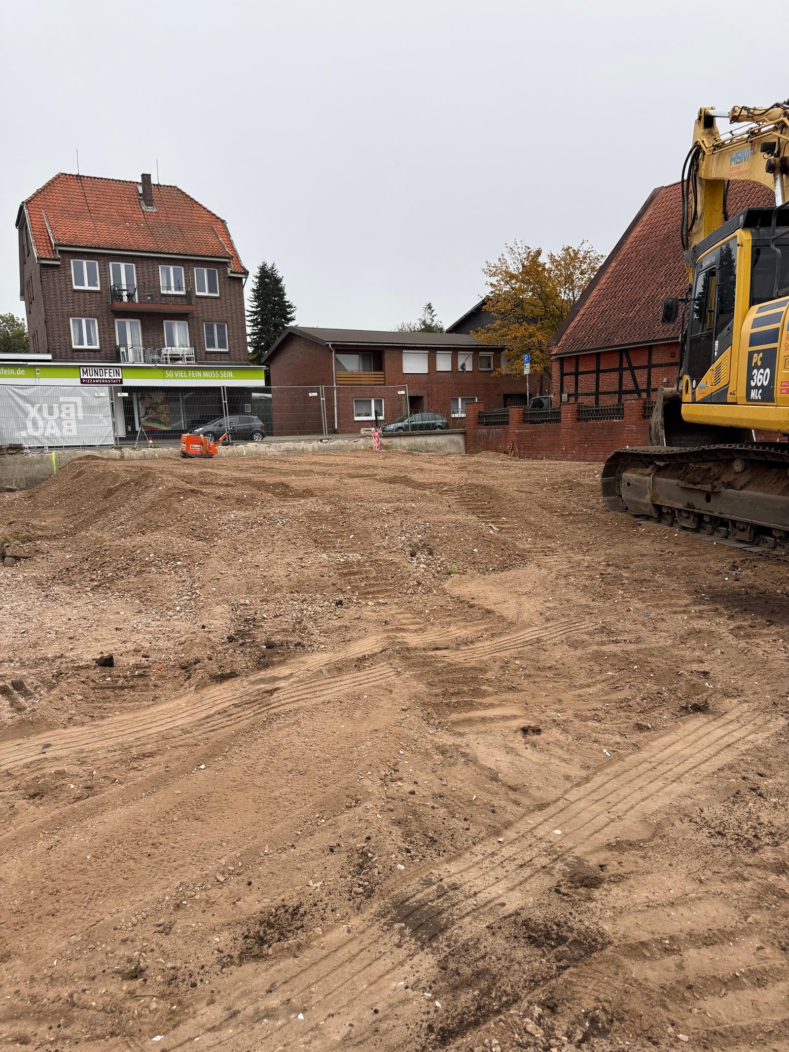Gelber HSM-Bagger auf einem geräumten Baufeld beim Erdaushub