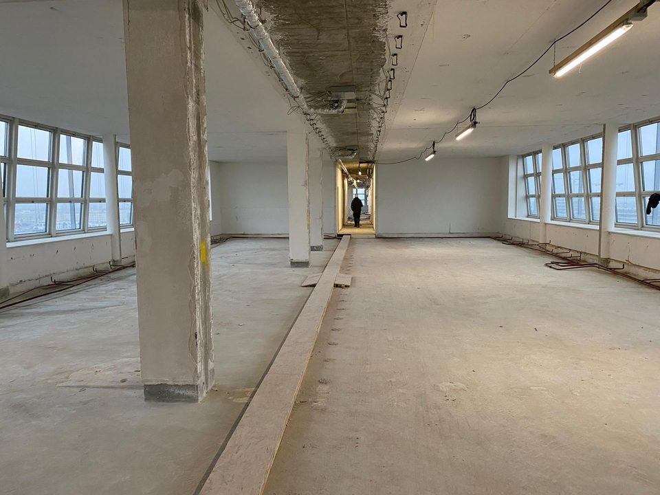 Entkernte Bürogeschoss-Etage mit Betonstützen und Panoramafenstern beim Innenrückbau
