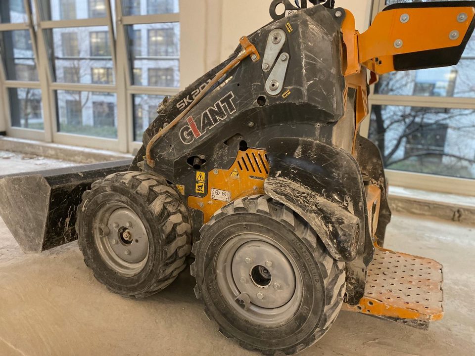 Staubiger GIANT Mini-Radlader auf einer entkernten Etage der Rückbaustelle