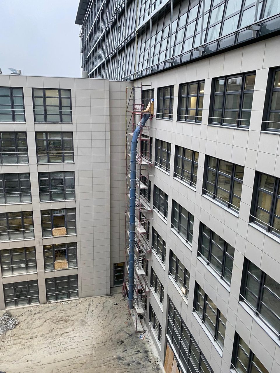 Blaue Schuttrutsche an der Fassade im Innenhof der Rückbaustelle