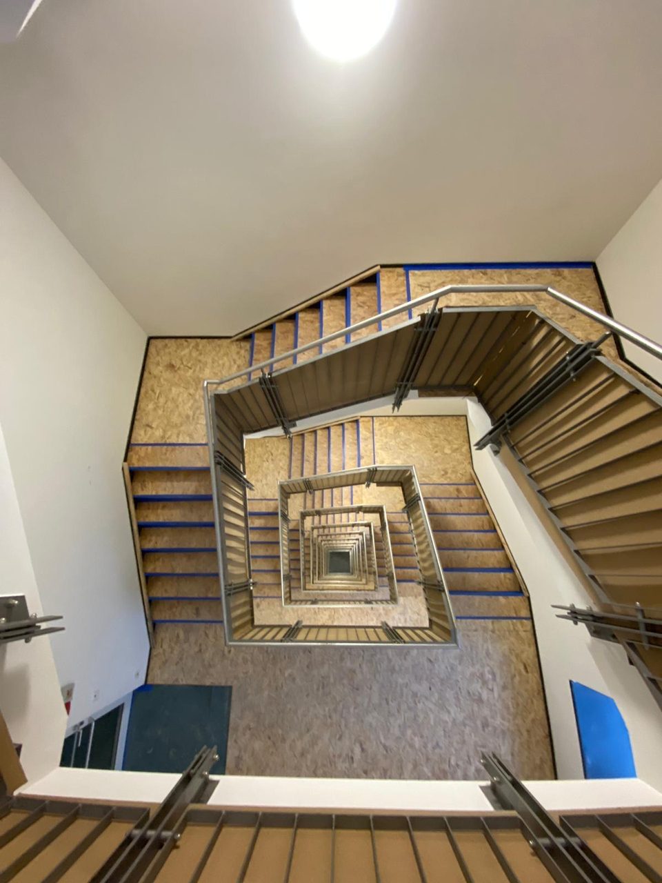 Blick ins quadratische Treppenauge mit OSB-Wandschutz während des Rückbaus