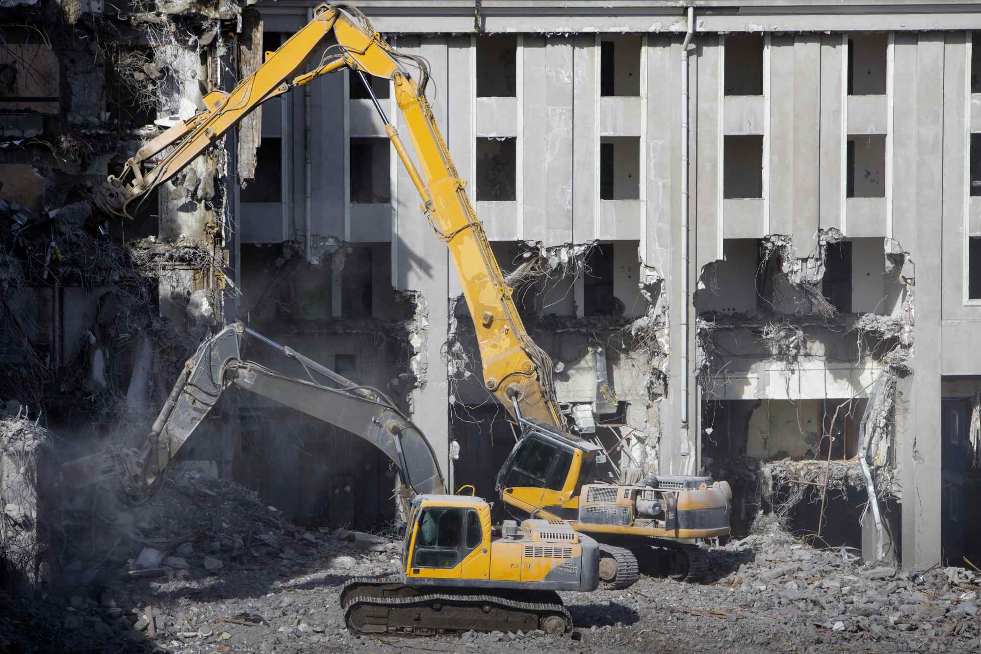 Building of the former hotel demolition for new construction, using a two special hydraulic excavator-destroyer. Complete highly mechanized demolition of building structures. Construction site